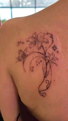 the back of a woman's shoulder with flowers on it