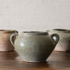 three vases sitting on top of a wooden table