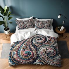 the comforter is made up with an intricate paisley pattern on it, along with two pillows