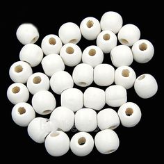 white round beads with holes in the middle on a black background for use as beading