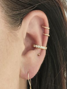 a close up of a person's ear with two small gold hoops on it