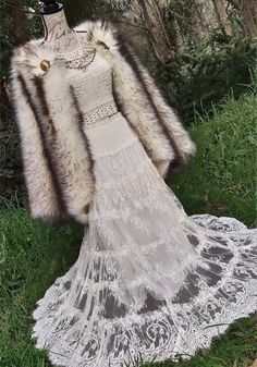 a dress and fur coat on display in the grass