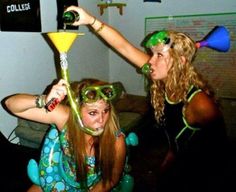 two young women wearing party hats and glasses, one holding a martini glass while the other holds a wine bottle