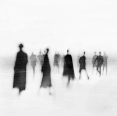 black and white photograph of people walking in the snow