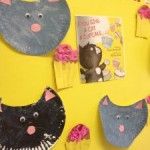 a bulletin board decorated with cat and cupcakes on yellow paper plated surface