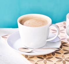 two cups of coffee sitting on top of a saucer