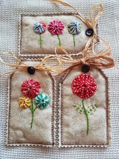 three tags with flowers on them tied together