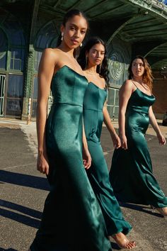 two women in green dresses are walking down the street with their feet on the ground