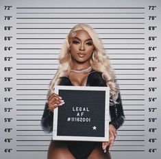 a woman in a bodysuit holding a sign that says legal is $ 20 00