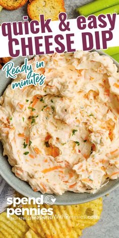 a bowl filled with cheese dip next to some crackers and celery sticks