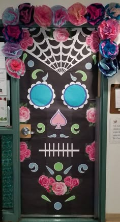 a classroom door decorated with paper flowers and a skull