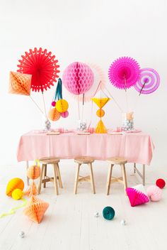 a table topped with lots of colorful paper fans next to other decorations on top of it