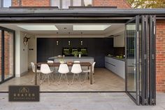 an open kitchen and dining room area in a house with glass doors leading to the outside