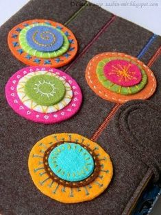 an ipad case is decorated with colorful felt circles and thread spools on it