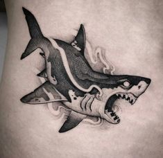 a black and white photo of a shark tattoo on the side of a woman's stomach