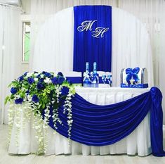 a blue and white wedding set up with flowers