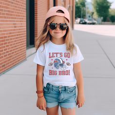 Get your mini fan geared up with the Let's Go Big Bro! football tee! 🏈 Whether your little one is cheering from the sidelines or running circles around their "big bro," this shirt is perfect for showing off some sibling pride. With a football and helmet graphic, it's game day ready--no matter who's winning. 🏟️ Ready to tackle the fun? Gear up now and let the games begin! 🎉 #BigBroCheerleader Uplift any child's wardrobe with a custom kid's t-shirt. The Bella Canvas short sleeve tee for toddler Cute Short Sleeve T-shirt For Game Day, Pre-shrunk Fun T-shirt For Game Day, Fun Pre-shrunk T-shirt For Game Day, Fun Short Sleeve T-shirt For Game Day, Cute White T-shirt For Game Day, End Of School Year White T-shirt With Team Name, Casual T-shirt For Cheerleading, Fun White Tops For Game Day, Cute Short Sleeve Cheerleading T-shirt