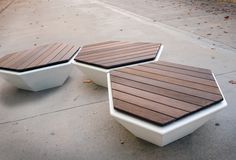 two white and brown benches sitting on the sidewalk