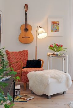 a living room filled with furniture and a guitar on the wall