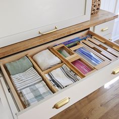 an open drawer with folded towels in it