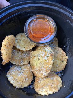 some fried food in a black bowl with dipping sauce