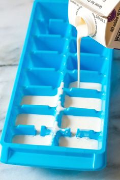 a bottle of milk being poured into an ice tray