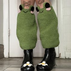 the legs and ankles of a woman wearing green knitted leg warmers with flowers on them