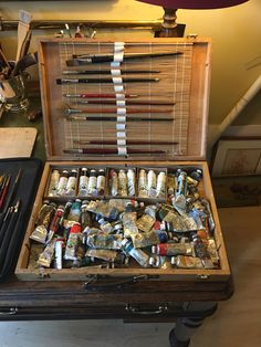 an old wooden box filled with lots of different types of paintbrushes and brushes