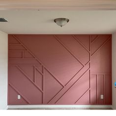 an empty room with pink walls and white floors