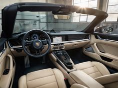 the interior of a luxury car with tan leather seats and dashboards, including steering wheel