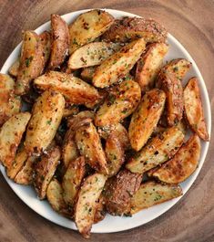 a white plate topped with fried potatoes covered in seasoning