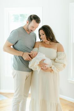 a man and woman holding a baby in their arms