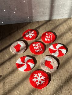 six red and white knitted coasters sitting on top of a wooden table next to a window