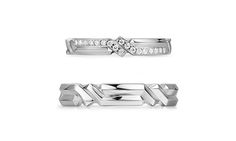 two wedding bands with diamonds on each side and an arrow in the middle, set against a white background