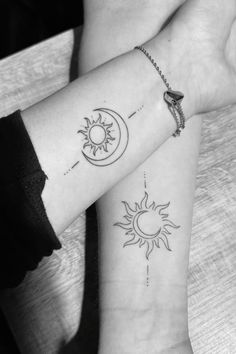 two sun and moon tattoos on both wrists, one is black and the other is white