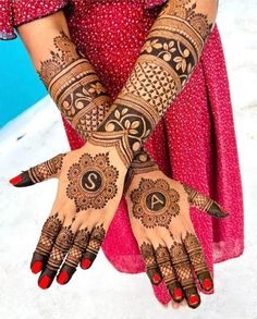 a woman's hands with henna tattoos on them