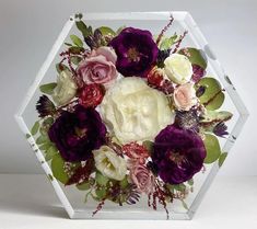 an arrangement of flowers in a hexagonal vase