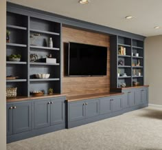 a large entertainment center with built - in cabinets and a flat screen tv mounted on the wall