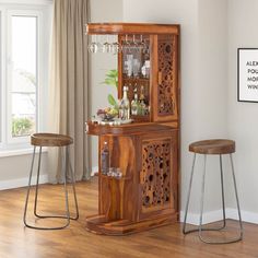 a wooden bar with two stools in front of it and a window behind it