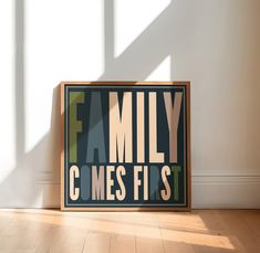 a family c mees first sign sitting on the floor in front of a white wall