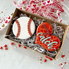 two decorated cookies in a box with confetti