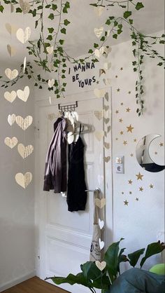 a room decorated with paper hearts and greenery