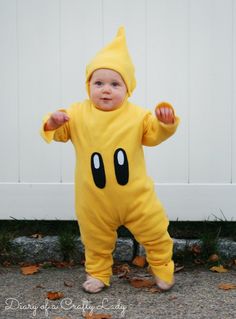 a baby in a pacman costume is standing on the ground with his hands up