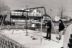 black and white photograph of two people at a playground