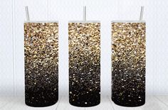 two tall vases with black and gold glitter on them