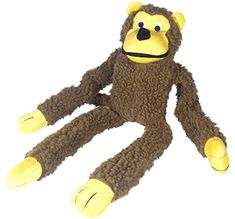 a stuffed monkey sitting on the ground with its legs spread out and eyes wide open