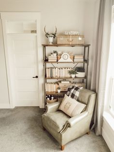 a living room with a chair, bookshelf and other items on the shelves