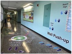 an empty hallway with hand prints on the floor and blue wall behind it that reads reach high