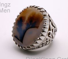 Elevate your style and energy with our meticulously handcrafted Dendritic Agate Shajri Aqeeq Ring. This exquisite piece showcases the captivating beauty of dendritic inclusions, resembling delicate tree-like formations within the stone. Crafted with care and precision, this natural gemstone ring not only adds a touch of elegance to your look but also holds the potential for healing and positive energy. The unique patterns within the agate are believed to connect you with the grounding energy of nature while enhancing your inner strength. Our limited edition Dendritic Agate Shajri Aqeeq Ring is more than just jewelry - it's a statement of your individuality and a reflection of your appreciation for the natural world. Treat yourself or a loved one to this one-of-a-kind piece that's bound to Formal Agate Rings With Natural Stones, Elegant Agate Rings For Collectors, Luxury Agate Rings, Luxury Round Agate Rings, Luxury Agate Ring Jewelry, Traditional Round Agate Jewelry, Traditional Agate Rings With Polished Finish, Traditional Agate Jewelry For Collectors, Dendritic Agate Rings