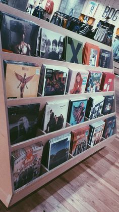 a book shelf filled with vinyl records in a store or music store, showing the album covers